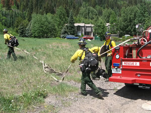 The Vail Fire Department's wildland firefighting team rolls out hoses during training near East Vail's Bighorn Park Monday.