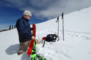 Strapping synthetic seal skins onto a fat pair of telemark skies isnt always easy, and most backcountry skiers will chose a skinnier ski for this kind of trip. Here the author rigs a set of ropes to his skins to help keep them fastened to the wide base of the ski.