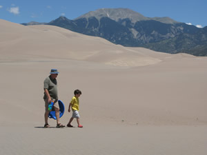 With the Sangre de Cristo Mountains as a backdrop, Robert Kenney and his grandson, Nicholas Williams, trudge across the Great Sand Dunes north of Alamosa.